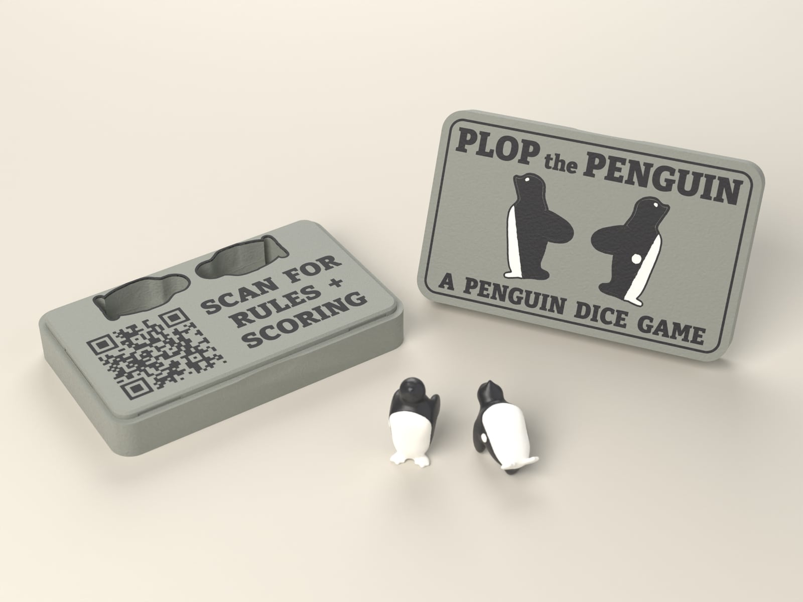 The open Plop the Penguin case with its lid standing beside it and two penguin dice in front